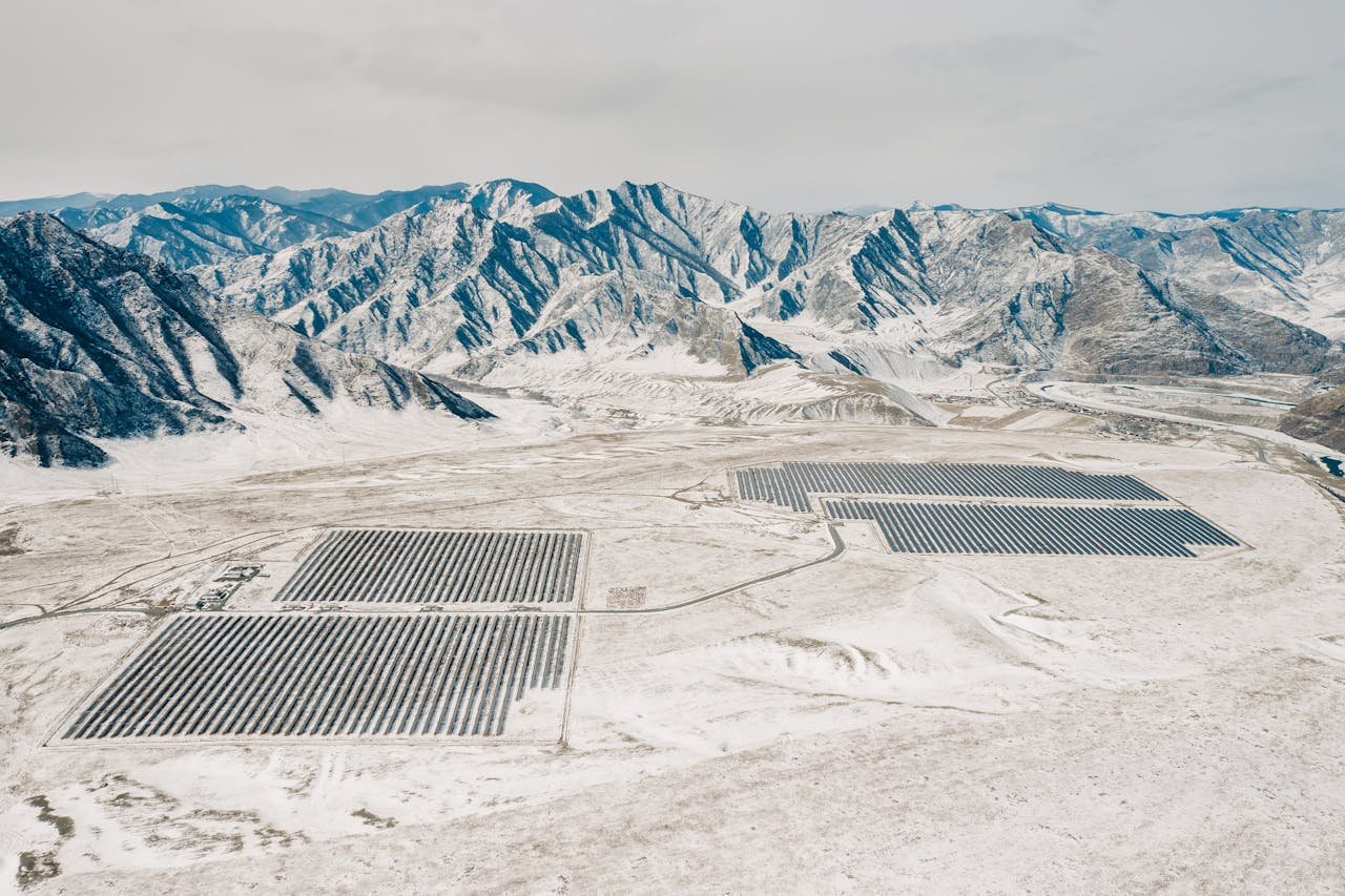 services-01 Aerial shot of a solar farm amidst snow-covered mountains in Altay, Russia.